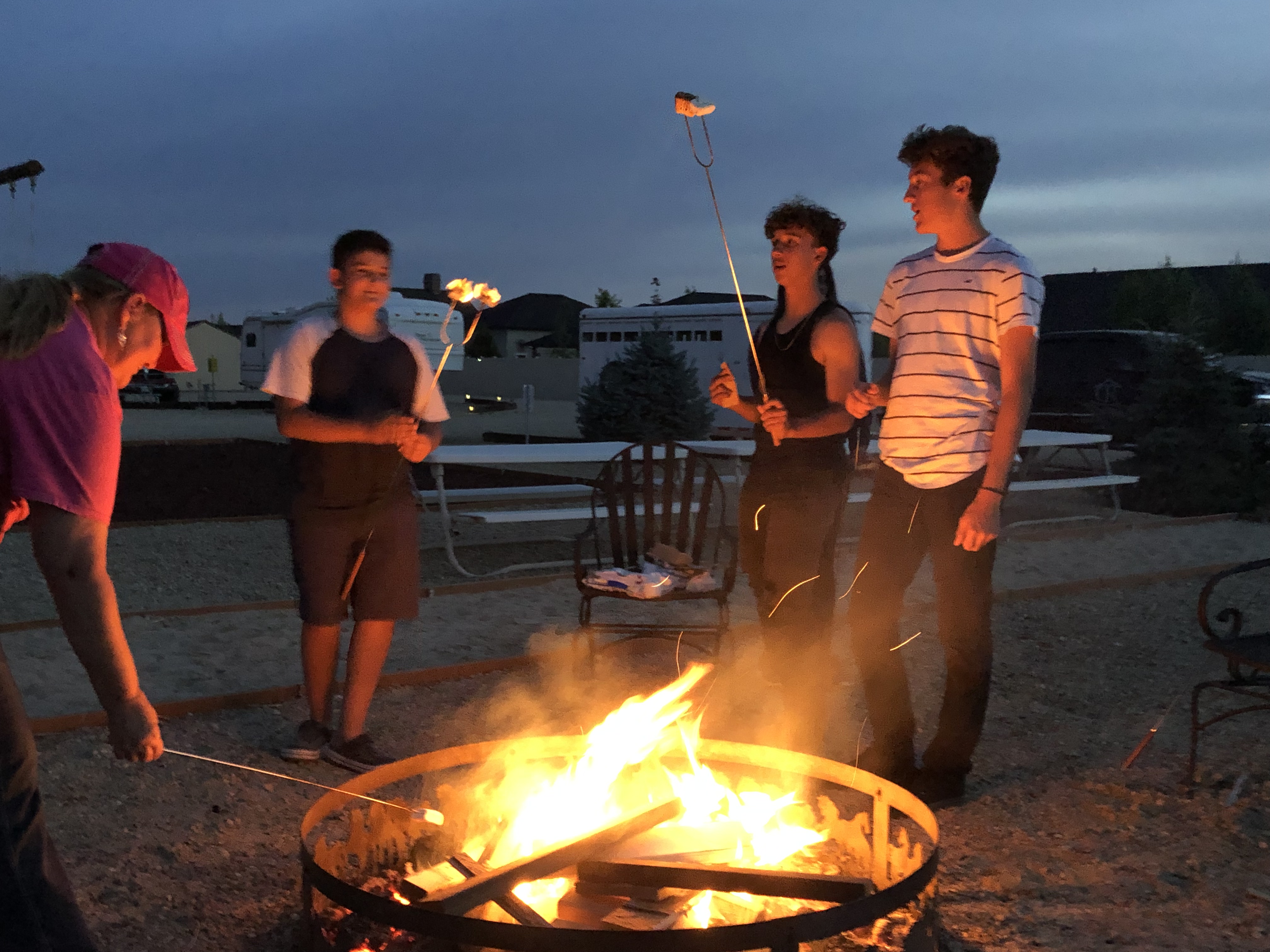 Soccer team enjoying smores by the fire.